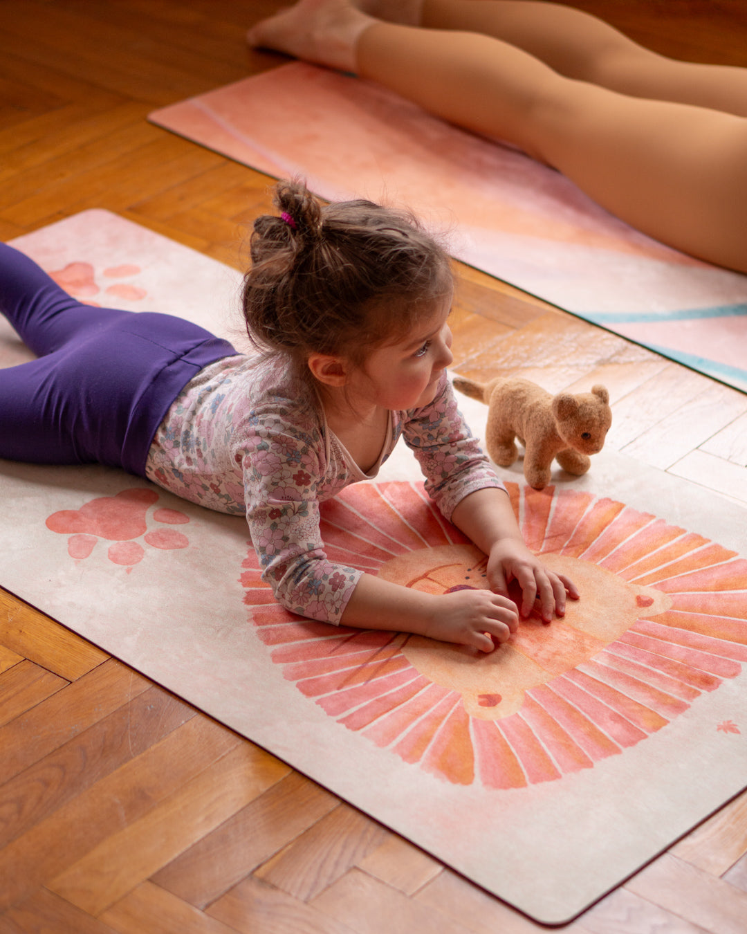 Kind liegt auf Kinder Yogamatte von MALA im Design Little Lion mit Löwen und Löwentatzen in Wasserfarben