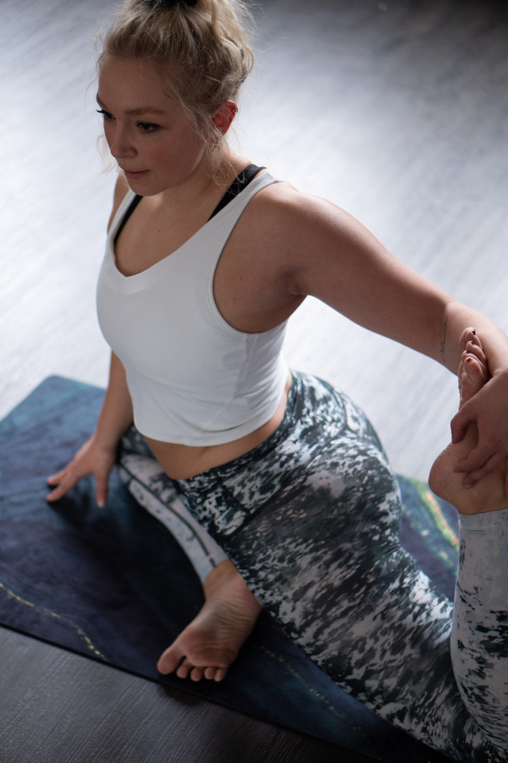 Yogapose auf 2-in-1-Yogamatte und Handtuch von MALA Yoga im Design Emerald Swirl in Edelstein Optik in den Farben grün und gold. Design im Acrylpouring Verfahren hergestellt.