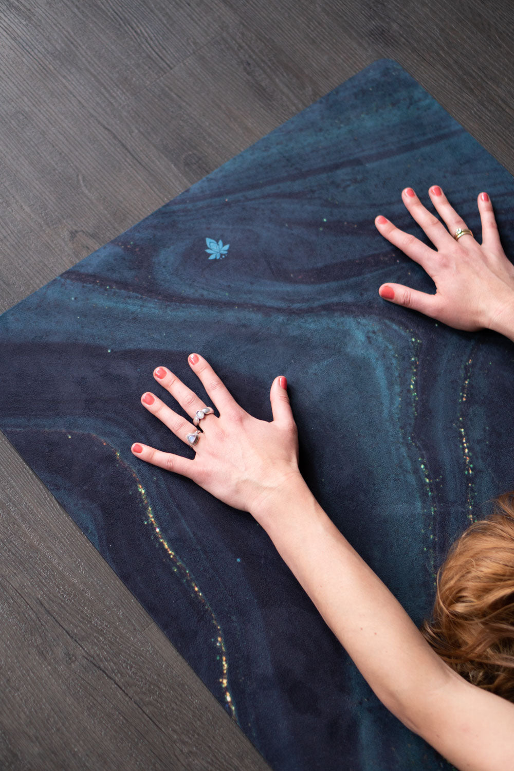 Hände auf 2-in-1-Yogamatte und Handtuch von MALA Yoga im Design Emerald Swirl in Edelstein Optik in den Farben grün und gold. Design im Acrylpouring Verfahren hergestellt.