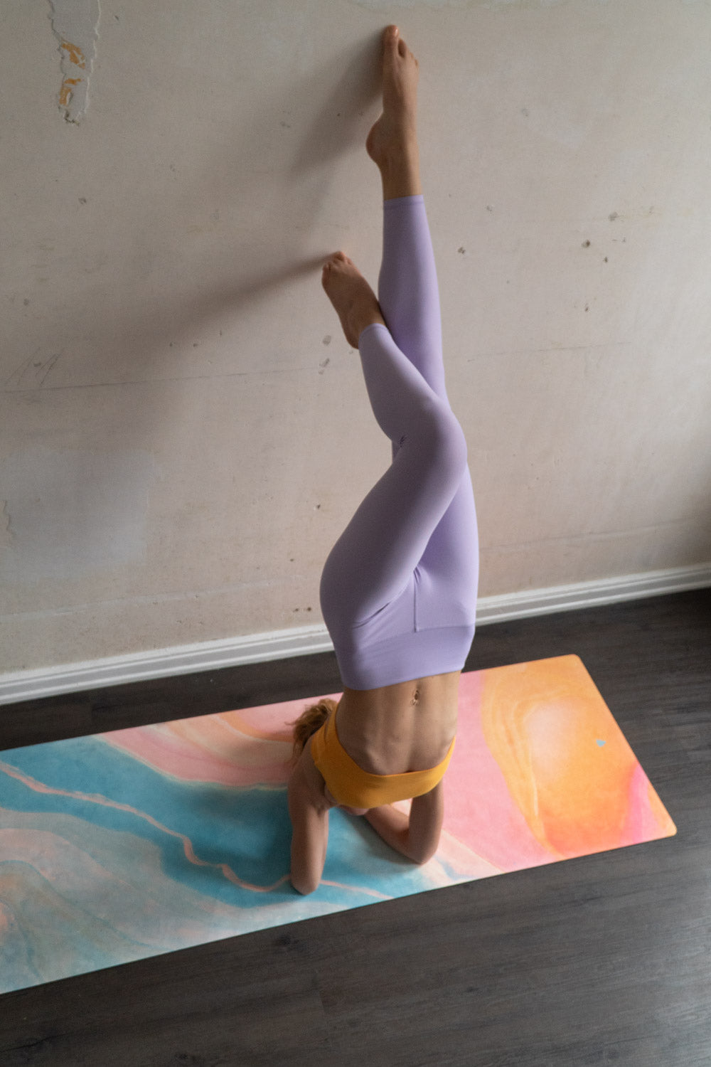 Frau macht Yoga auf 2-in-1-Yogamatte und Handtuch von MALA Yoga im Design Mango Smoothie in leuchtenden Farben. Design im Acrylpouring Verfahren hergestellt.