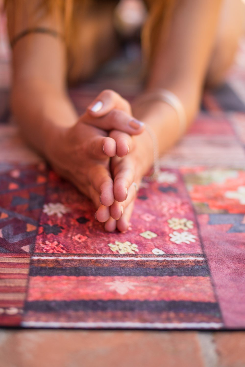 Hände auf 2-in-1-Yogamatte und Handtuch von MALA Yoga im Design Marrakesh. Teppich Muster.