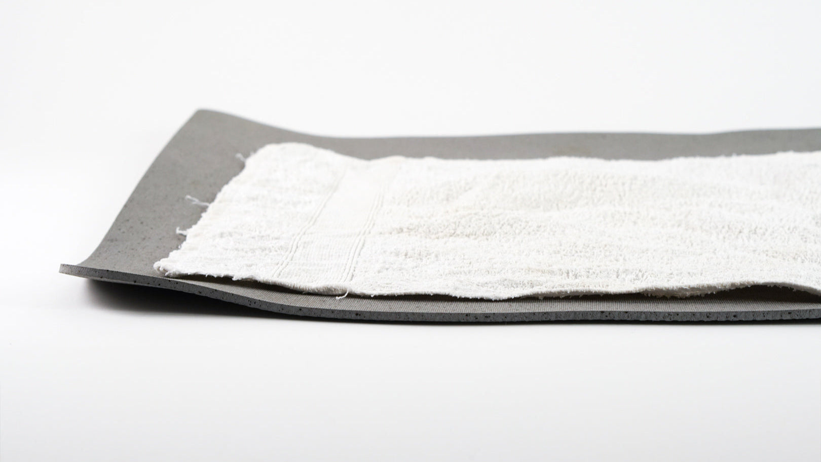 Herkömmliche Yogamatte mit zusätzlichem Handtuch und aufgestellten Kanten