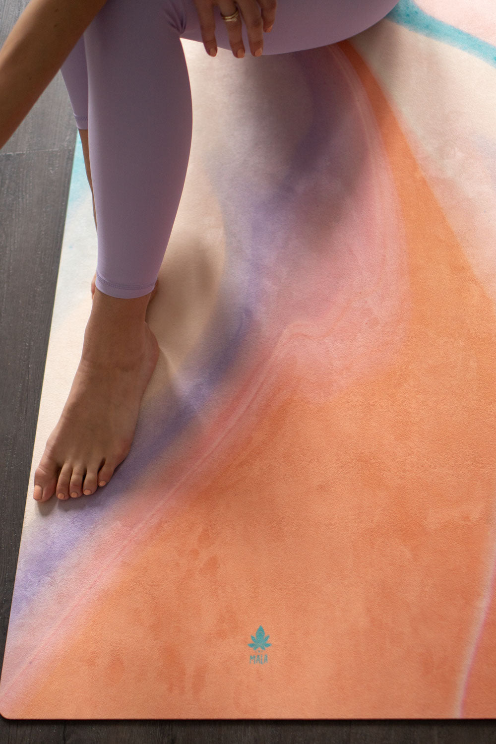 Füße auf 2-in-1-Yogamatte und Handtuch von MALA Yoga im Design Apricot Ink in den Farben aprikot und türkis. Design im Acrylpouring Verfahren hergestellt.